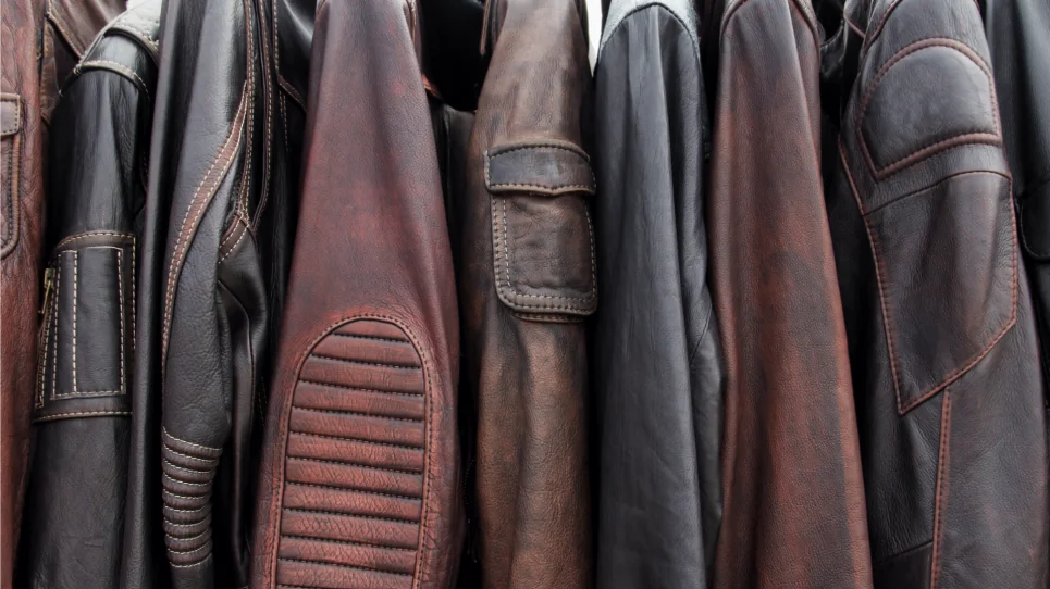 A collection of leather jackets on hangers